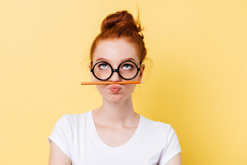 Poster - Funny ginger woman in eyeglasses playing with pencil