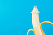 Condom and banana on a blue background close-up