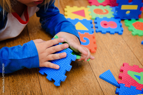 Fotomural little girl playing with puzzle, early education