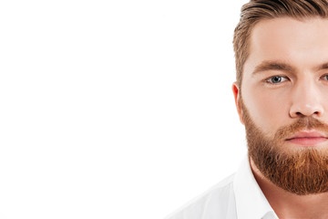 Wall Mural - Handsome young bearded man standing over white wall