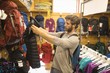 © Wavebreak Media - Young man examining lifeguard jackets in store