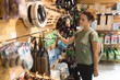 © Wavebreak Media - Woman examining sports equipment in store