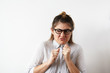 © shurkin_son - Portrait of funny Caucasian businesswoman wearing glasses and white shirt clenched fists on the chest wishing for the fall sales to its competitors. Body language and negative facial expression