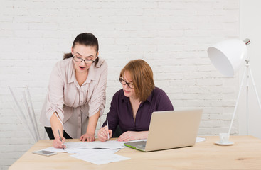 Teamwork. Women discuss project in office