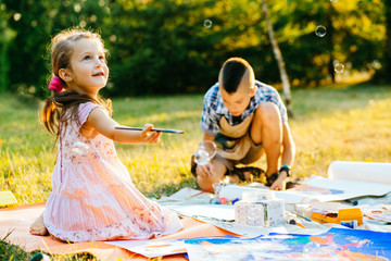 Wall Mural - Portrait of two children painting, summer outdoor. Art, drawing and kids creativity concept.