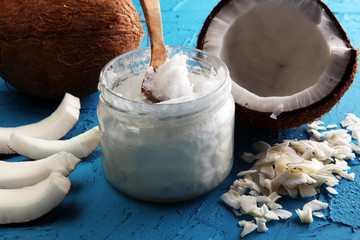 Wall Mural - coconut oil and fresh coconuts on blue background