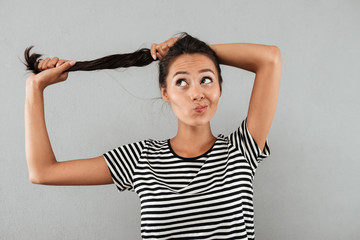 Canvas Print - Pretty asian girl playing with her long hair while standing