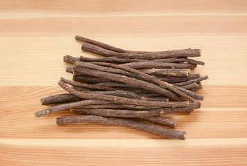 Wall Mural - Pile of liquorice root on wood