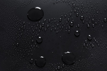 Water drops on a rough black surface