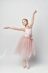 Wall Mural - 1456844 girl ballerina in a pink tutu dancing against a white background
