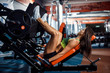 © ZaStock - Woman doing fitness training on a leg extension push machine with weights in a gym