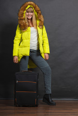 Wall Mural - Happy young woman in warm jacket with suitcase.