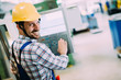 © NDABCREATIVITY - Industry Worker entering data in CNC machine at factory