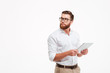 © Drobot Dean - Serious young bearded man using tablet computer.