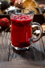 Wall Mural - Christmas hot cranberry tea or mulled wine and assorted cookies on dark table, vertical closeup