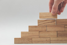 Male Hand Stacking Wooden Blocks. Business Development And Growth Concept