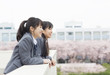© amanaimages - Two high school girls on rooftoplooking away