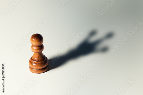 Fotografía trust yourself concept - chess pawn with king shadow