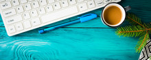Workplace Winter Background With Keayboard, Notebook And Coffee On Dark Green Wooden Background And Green Branch. Online Blog Concept