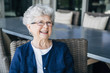 © Cavan Images - Smiling senior woman relaxing on porch