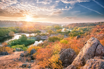 Wall Mural - mountain river among stony shores at sunset