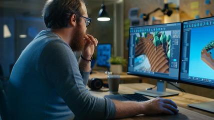 Wall Mural - creative male game developer works with graphics for the new level design, he sits at his wooden tab
