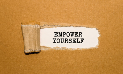 Wall Mural - The text EMPOWER YOURSELF appearing behind torn brown paper