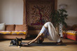 © michela ravasio/Stocksy - Young woman doing downward facing dog at home
