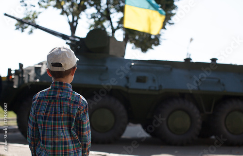 Plakat chłopiec patrzy na czołg z flagą Ukrainy