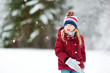 © MNStudio - Adorable little girl having fun in beautiful winter park. Cute child playing in a snow.