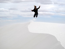 Woman Jumping In White Sands National Monument, USA