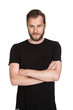 © _robbie_ - Mature staring man with beard wearing a black t-shirt standing against a white background looking at camera.