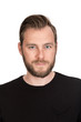 © _robbie_ - Mature staring man with beard wearing a black t-shirt standing against a white background looking at camera.