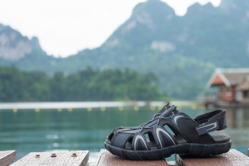 couple hiking sandals on mountain near river on nature background. Trekking shoes of family, man and woman. Travel healthy active lifestyle. Outdoor freedom. Feet selfie.