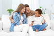 © Africa Studio - Happy couple with adopted African-American boy sitting on couch at home