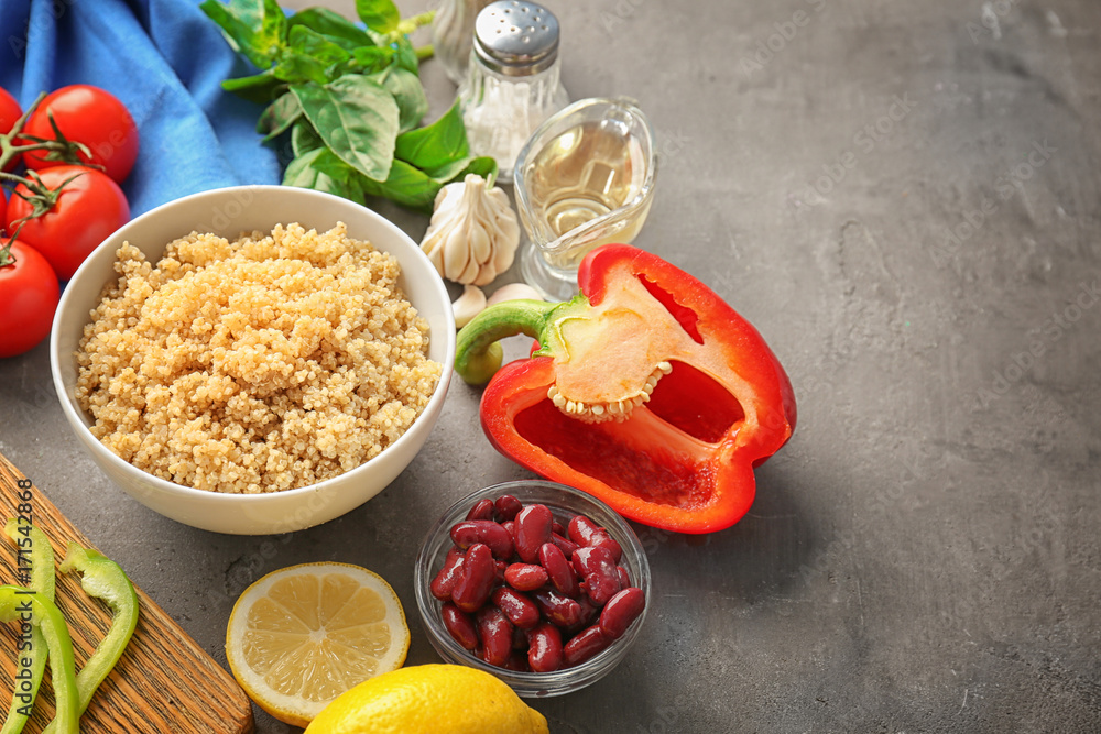 Composition with cooked quinoa and fresh products on grey background