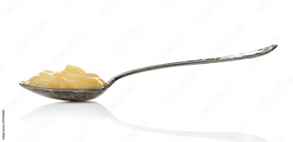 Metal spoon with vanilla pudding on white background