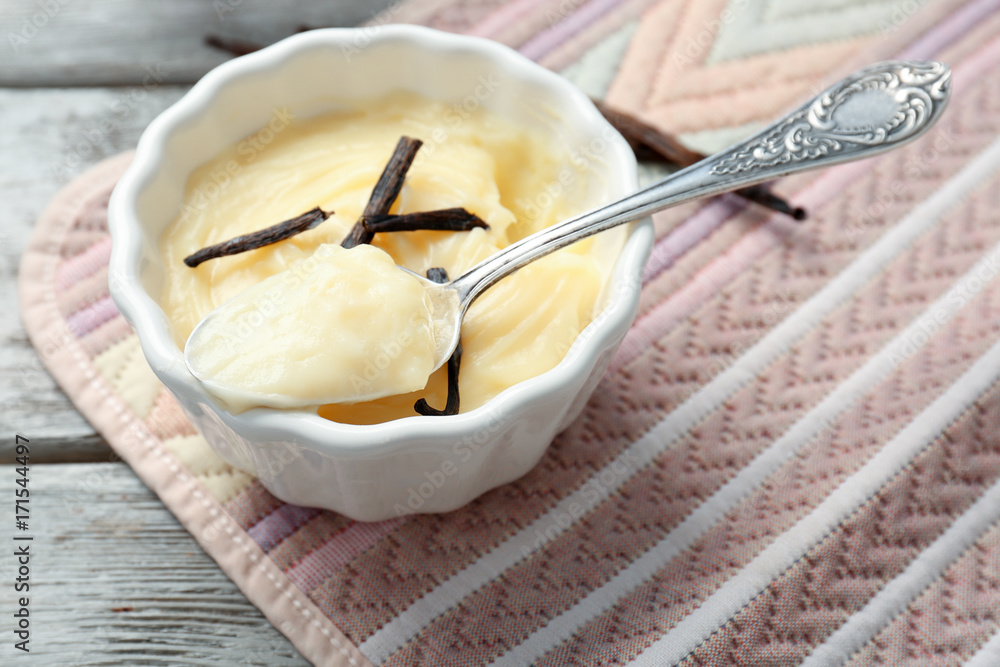 Vanilla pudding in ceramic bowl on color fabric