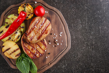 Wall Mural - Composition with tasty grilled steaks on table