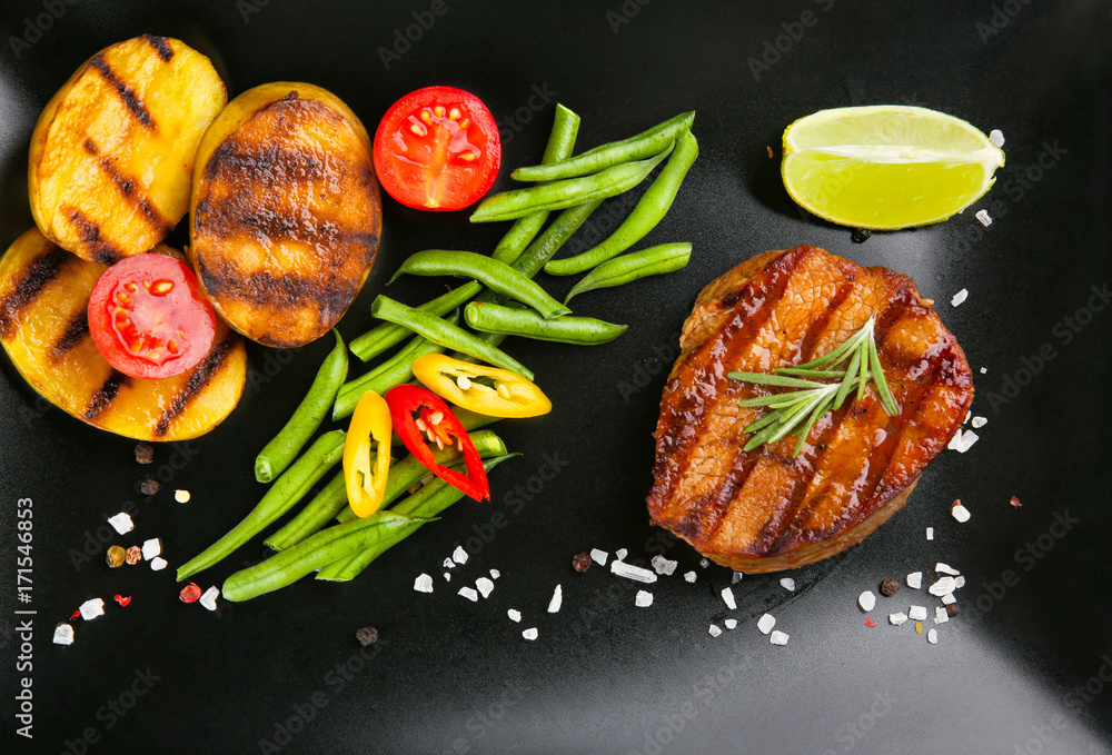 Composition with tasty grilled steak and vegetables on table