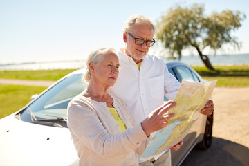 Canvas Print - senior couple at car looking for location on map