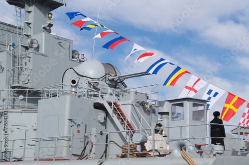 Plakat Najwyższa część wielkiego pancernika wojskowego z wieżami, masztami, flagami kolorowania i antenami