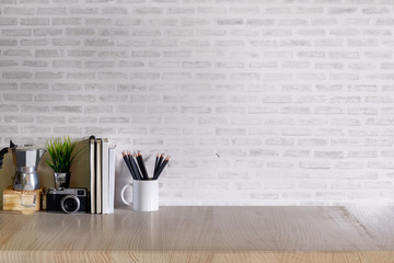 Work space Mock up : wood desk tabletop with notebooks, vintage camera and houseplant. white marble desk with copy space for products display montage.