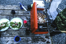 Overhead View Of Man Preparing Food On Barbeque At Campsite