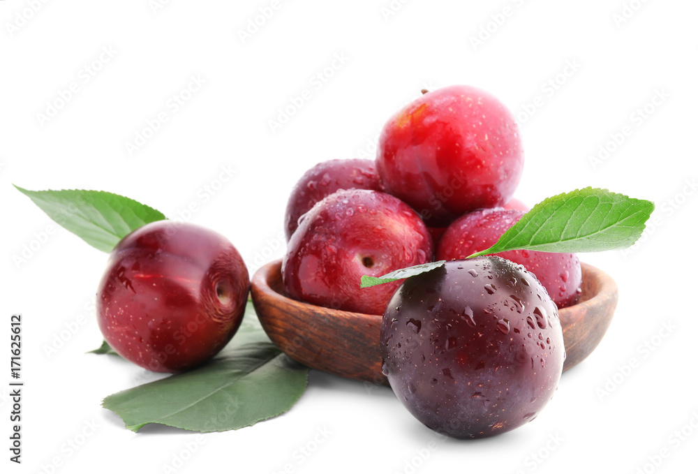 Bowl with fresh ripe plums on white background