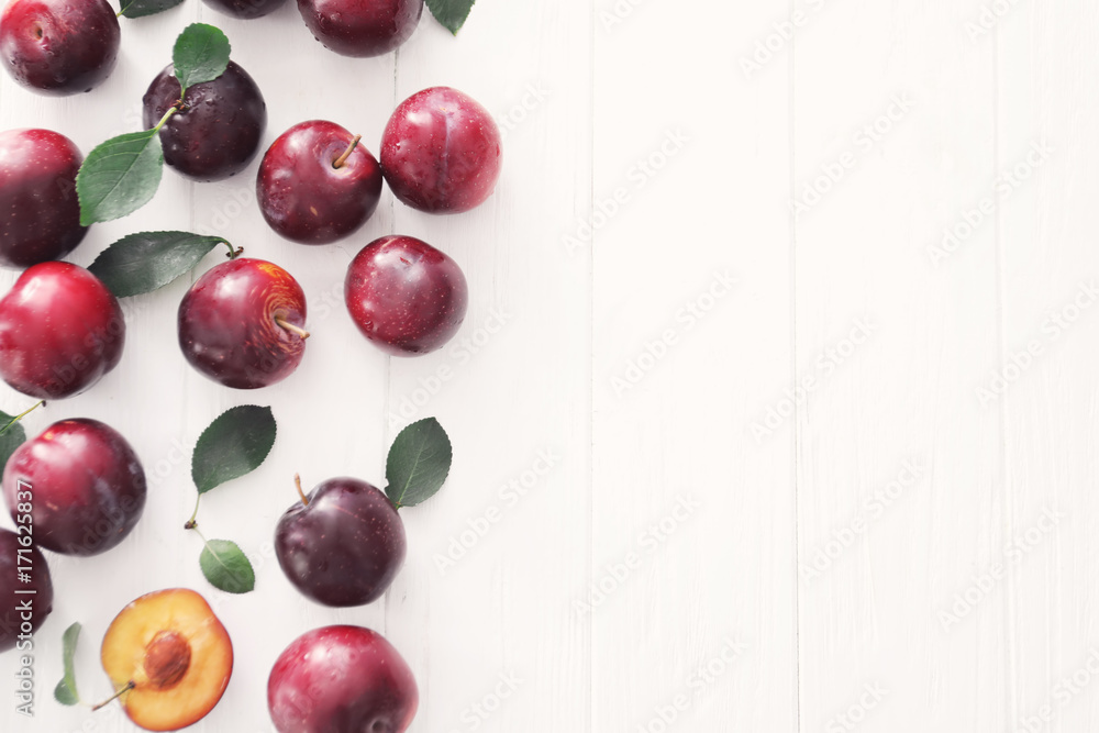 Fresh ripe plums on white background