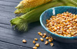 Bowl with corn kernels on wooden background