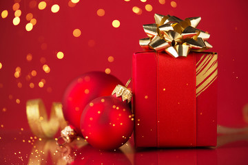 Wall Mural - red gift box with ornaments and ribbons on red holiday background with twinkle bokeh light. merry ch