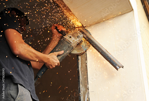 Fotografie, Obraz Blacksmith cutting iron profiles with rotaflex
