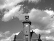 Das Alte Hafenamt in Dortmund in Westfalen mit Turmuhr und Turmspitze vor Himmel mit weißen Wolken am Dortmund-Ems-Kanal, fotografiert in neorealistischem Schwarzweiß